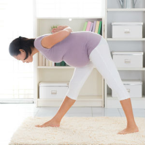 Pregnant lady practicing prenatal yoga pose
