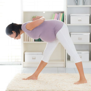 Pregnant lady practicing prenatal yoga pose